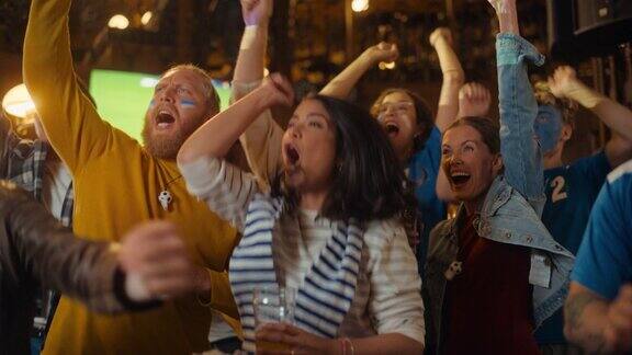 一群不同的朋友在体育酒吧看电视直播的足球比赛兴奋的球迷欢呼和喊叫当球队进球并赢得足球世界杯时年轻人庆祝