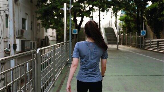后视图年轻的亚洲女子运动员走在街上后一个跑步日落时分在街上慢跑锻炼的生活方式健康的生活方式