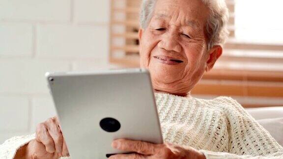 亚洲老年女性患者在家里用平板电脑与医生进行视频会议老年假期、技术、人、退休、生活方式、全球、医学教育、医疗咨询、医疗保健和医学概念高级技术