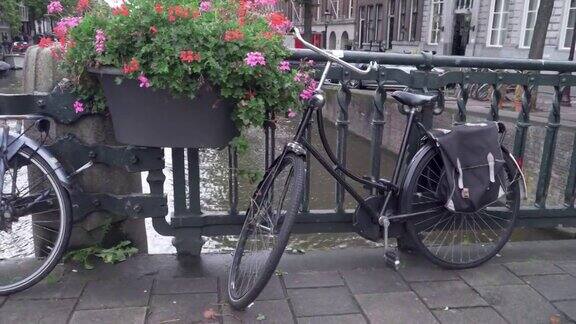 自行车停在阿姆斯特丹沿运河的街道桥的栅栏内天气恶劣视野开阔