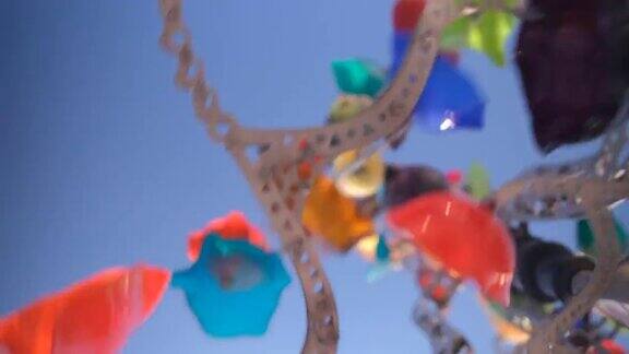 玻璃玩具旋转木马的背景是太阳多风的彩色风向标天空发光级联埃里温..