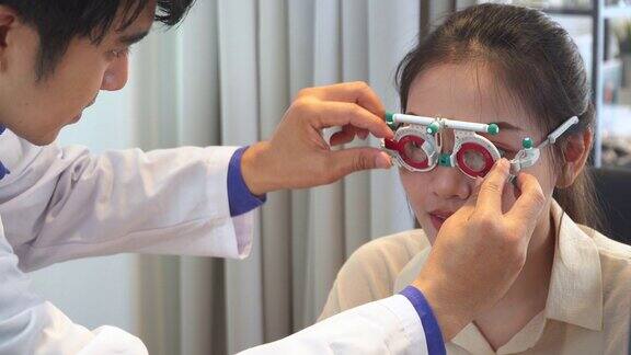 验光师为亚洲年轻女性调整镜头和距离试镜架准备配眼镜表达积极的情绪微笑以获得更好的视力