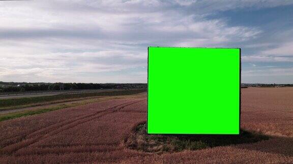 无人机拍摄的日落时分繁忙的高速公路或高速公路附近的绿色大屏幕广告牌