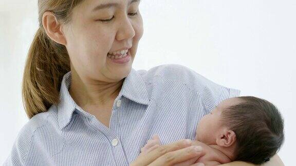 快乐的亚洲母亲在家里拥抱她刚出生的女儿亚洲家庭的幸福时刻