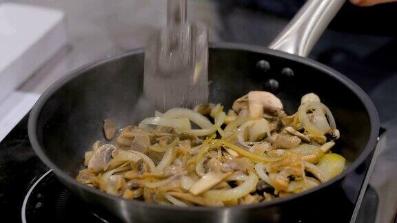 香菇和洋葱在平底锅里炸得滋滋作响