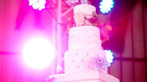 美丽的婚礼蛋糕装饰鲜花和蜡烛在婚宴上