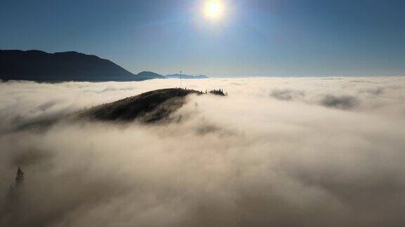 鸟瞰彩色日出在白色浓雾与遥远的黑暗轮廓山在地平线上