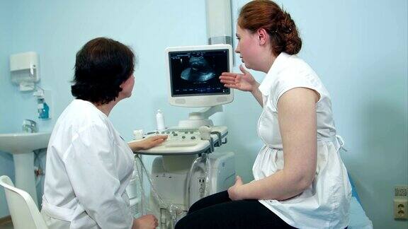 女医生在门诊给女病人看超声检查结果