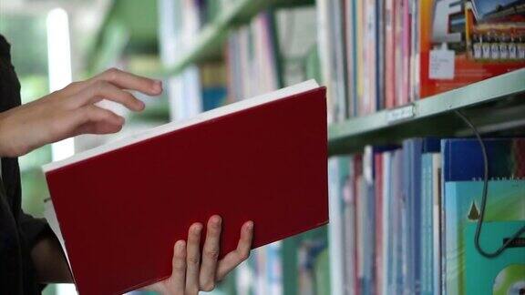 亚洲女孩找书翻阅并放回图书馆的书架上