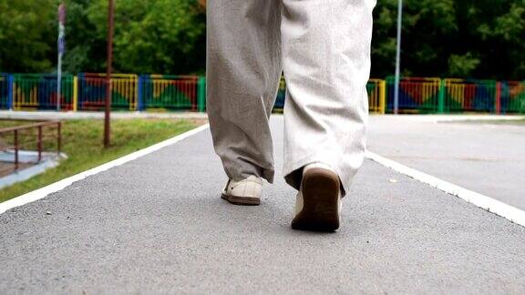 男人脚穿鞋走在瓷砖路上城市环境