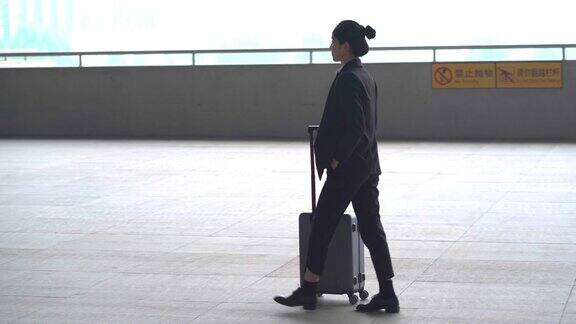 在机场提着行李箱的亚洲女人