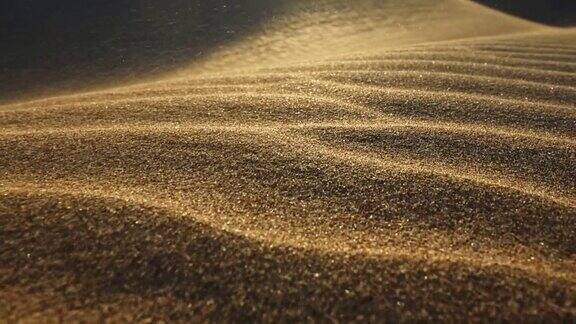 沙漠中的沙尘暴微距拍摄的沙粒被风吹走在落日的余晖中摄像机沿着沙漠中的沙丘表面移动沙子在风中飘动慢镜头