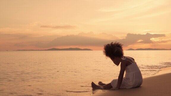 晚上一个非裔美国女孩孤独地站在海滩上