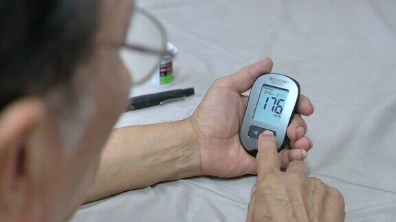 亚洲老年男性糖尿病患者在家使用血糖仪查看血糖结果