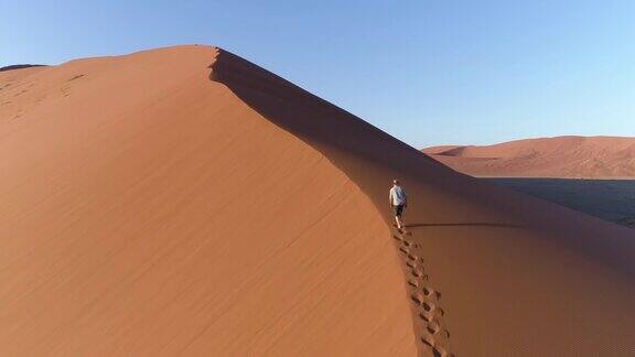 男游客在纳米布沙漠的沙丘上行走的鸟瞰图