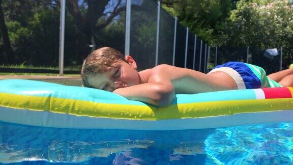 孩子躺在游泳池边的充气床垫上