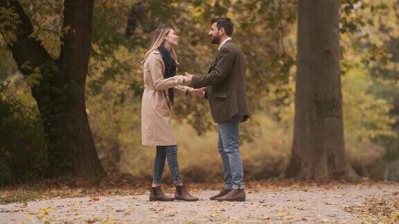 一对俊美的年轻夫妇漫步在秋天的公园里