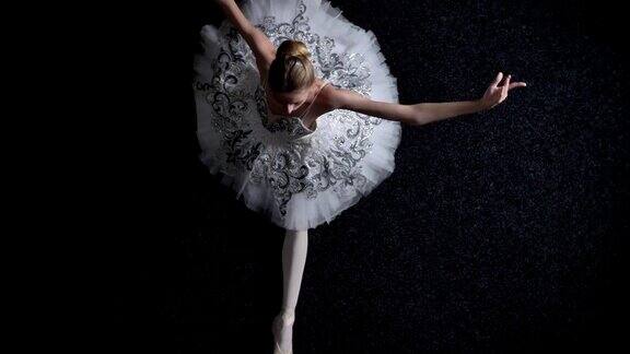 年轻优雅的女芭蕾舞演员的剪影坐在劈叉伸展概念芭蕾概念顶部镜头