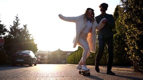 一个年轻的溜冰者教他的女朋友如何滑冰