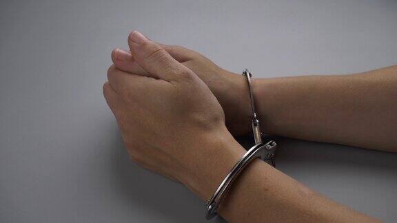 女性双手戴着手铐的特写因违法被捕为犯罪而悔恨