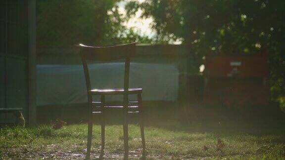 在一个有风的日子日落时农场里的一把椅子
