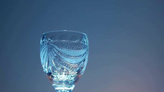 在移动的光线下将红葡萄酒从玻璃瓶倒入酒杯