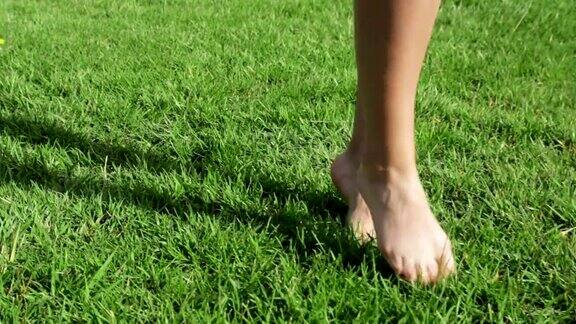女孩走在绿色草坪上的脚近距离