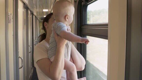 母亲带着可爱的小男婴坐火车妇女和儿童坐火车一家人靠窗坐火车