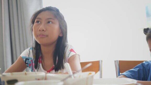 快乐的亚洲孩子在家里吃早餐一起聊天生活理念
