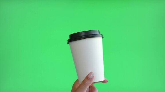 手拿咖啡杯的女人外卖手拿热饮标志模型的纸杯与盖子隔离在绿色色度的关键空白广告背景零浪费无塑料