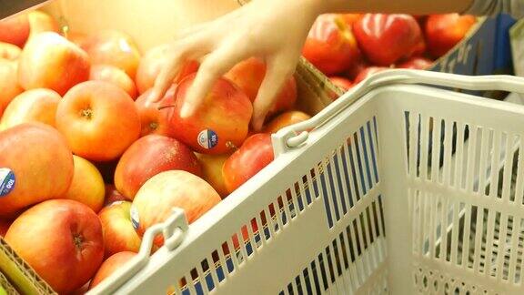 女人在超市买手挑选苹果