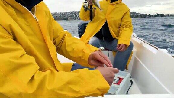 穿着黄色雨衣的人在钓鱼马鲛鱼风笛鱼