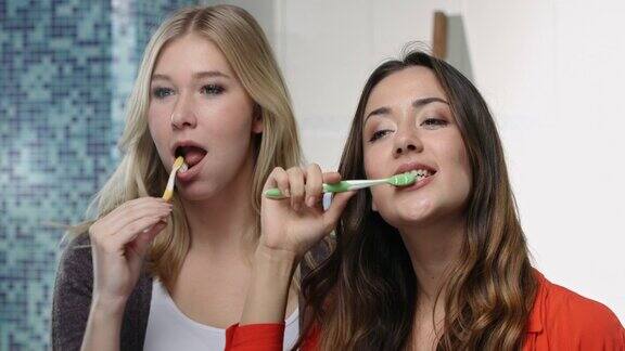 两个年轻女人在镜头前一起刷牙