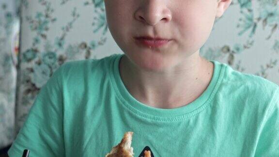 一个饥饿的十几岁的男孩正在吃大鸡块