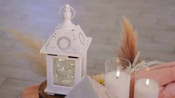 一座白色的小房子里面点着蜡烛附近的桌子上有两支燃烧的蜡烛