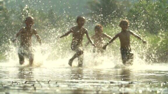 亚洲男孩玩在河与溅水一起玩(缓慢)