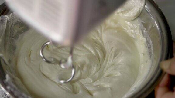 电动搅拌器把奶油放在搅拌碗里搅拌做成奶油甜点