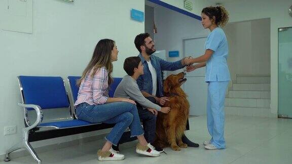 一个快乐的家庭在兽医离开他们的狗检查作为一个不错的助手带他与皮带