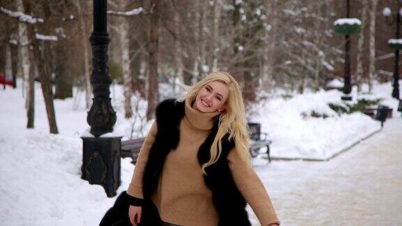 欢笑的年轻女子有乐趣在冬季公园