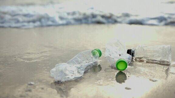 海浪把沙滩上的塑料瓶冲进海里海洋塑料垃圾污染管理问题环境问题拯救世界