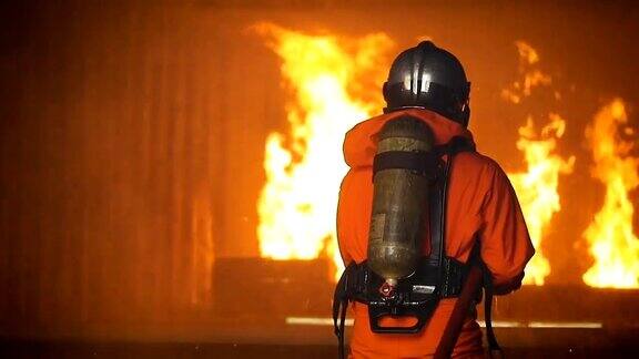 消防队员在灭火行动中高压水枪将水喷到火焰周围烟雾弥漫