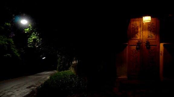在一个宁静的夜晚路边有一扇带灯的复古门晚上全景