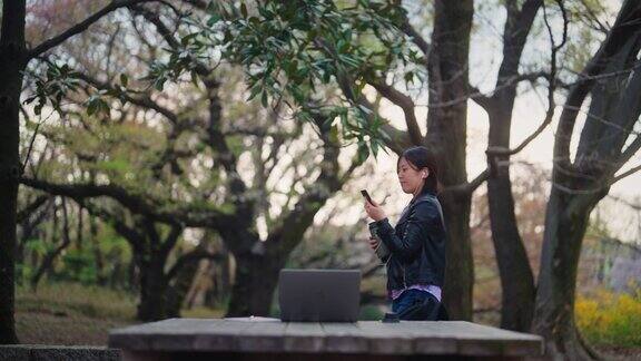 一名年轻女子在公园用笔记本电脑进行视频通话