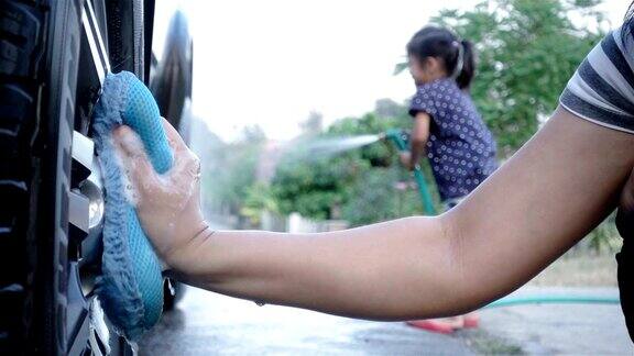 慢镜头特写一位女士和她的女儿在洗车