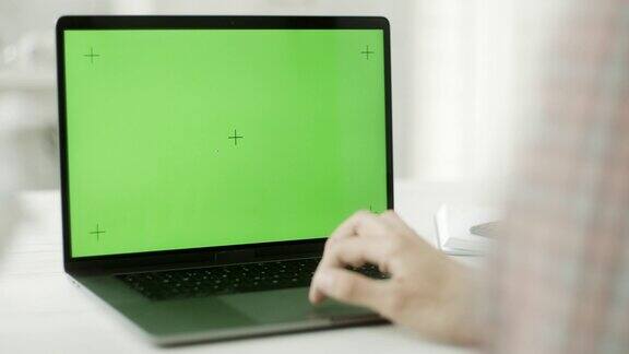 一个人在用绿色屏幕的笔记本电脑