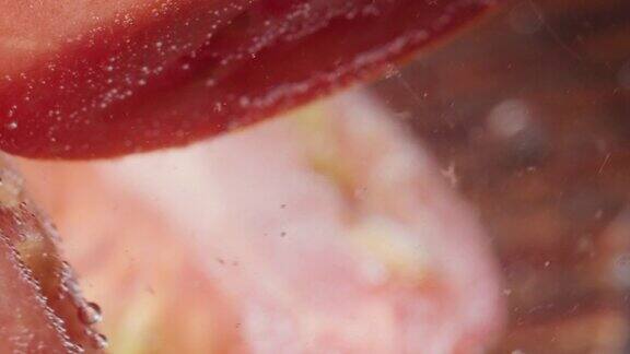 新鲜的番茄切片放在水面上极端特写镜头