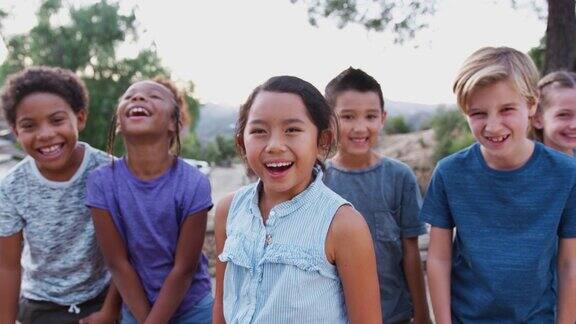 多文化儿童与欢笑的朋友在乡村一起闲逛的肖像