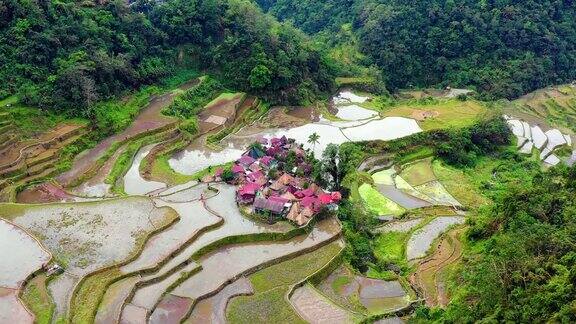 菲律宾梯田中间的一个小村庄在一个美丽的日子里在一个被群山包围的山谷里美妙的农业-用4K无人机鸟瞰图