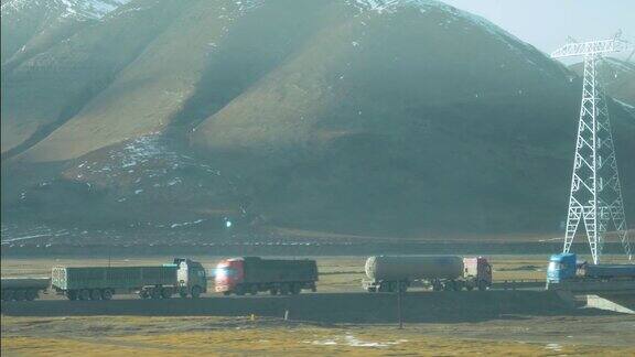 慢镜头:大型卡车在西藏平原上会合运送货物
