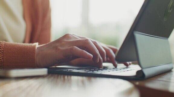 女性的手使用笔记本电脑在键盘上打字